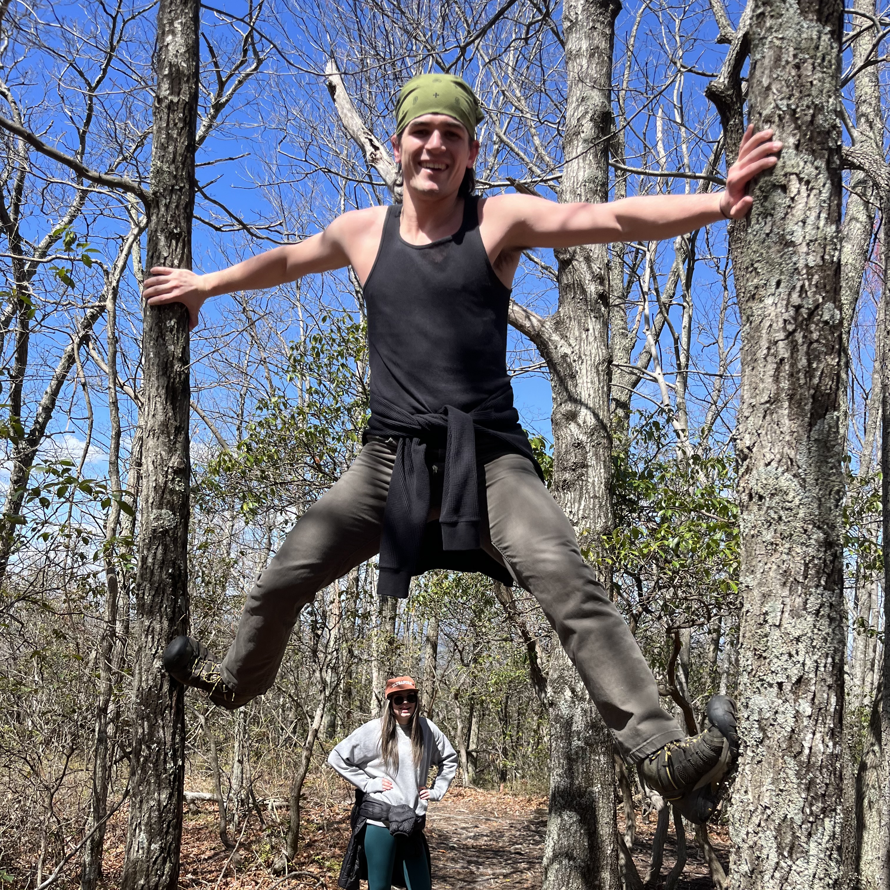Dom climbing up two trees.