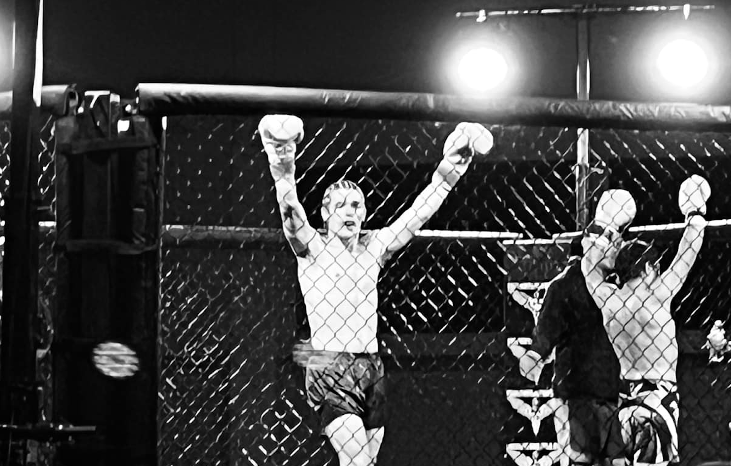 Dom's victory pose in cage after winner announcement of Kickboxing match.